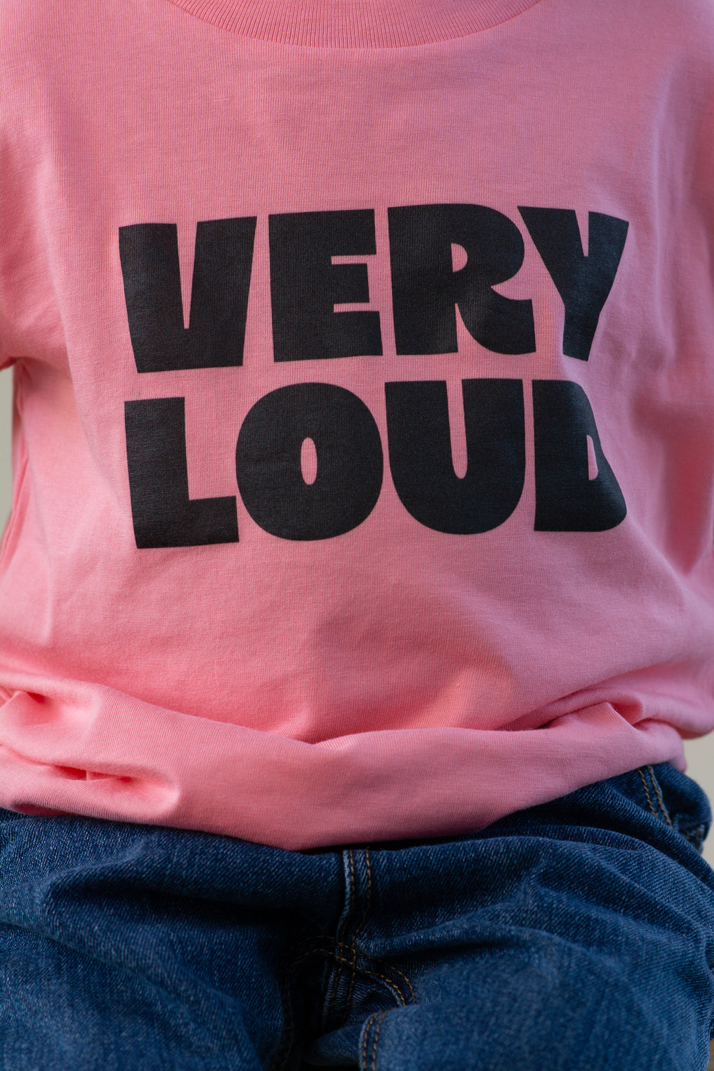 Pink t-shirt with 'VERY LOUD' text in black on a plain background