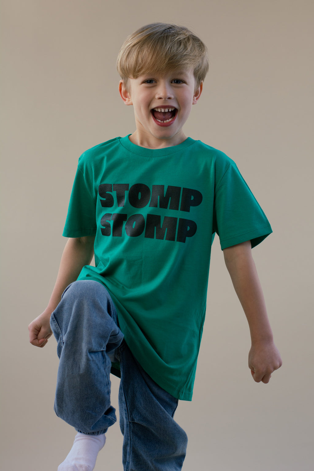 Child wearing a green 'STOMP STOMP' t-shirt on a plain background