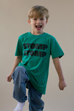 Child wearing a green 'STOMP STOMP' t-shirt on a plain background