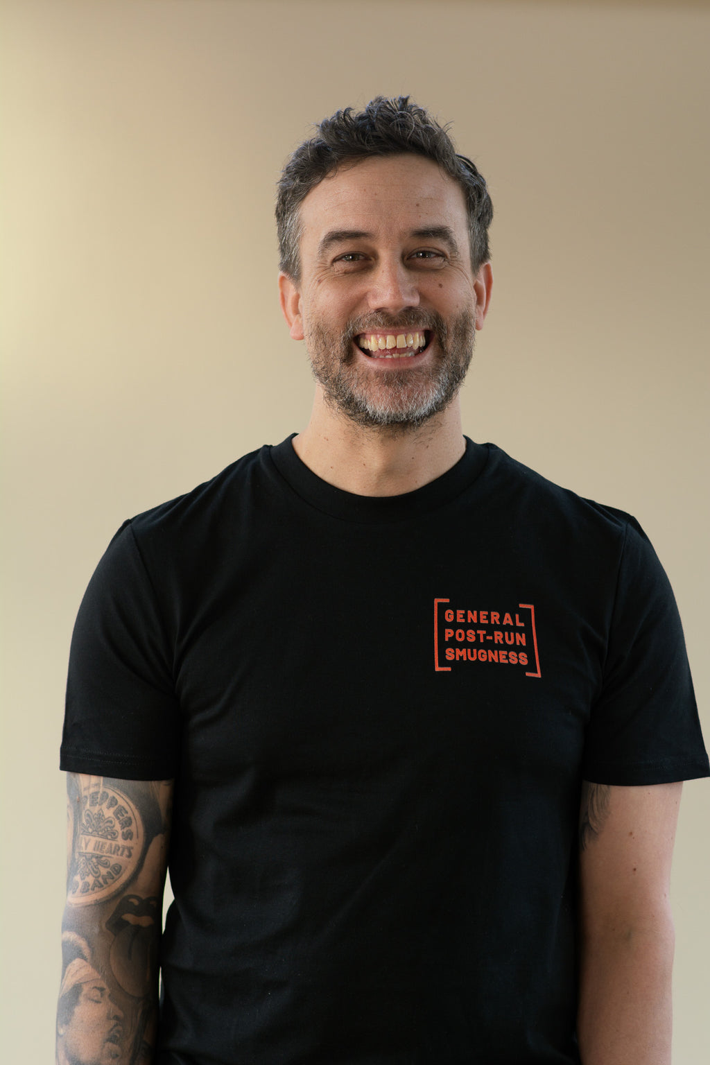 Man wearing a black t-shirt with orange text on a beige background