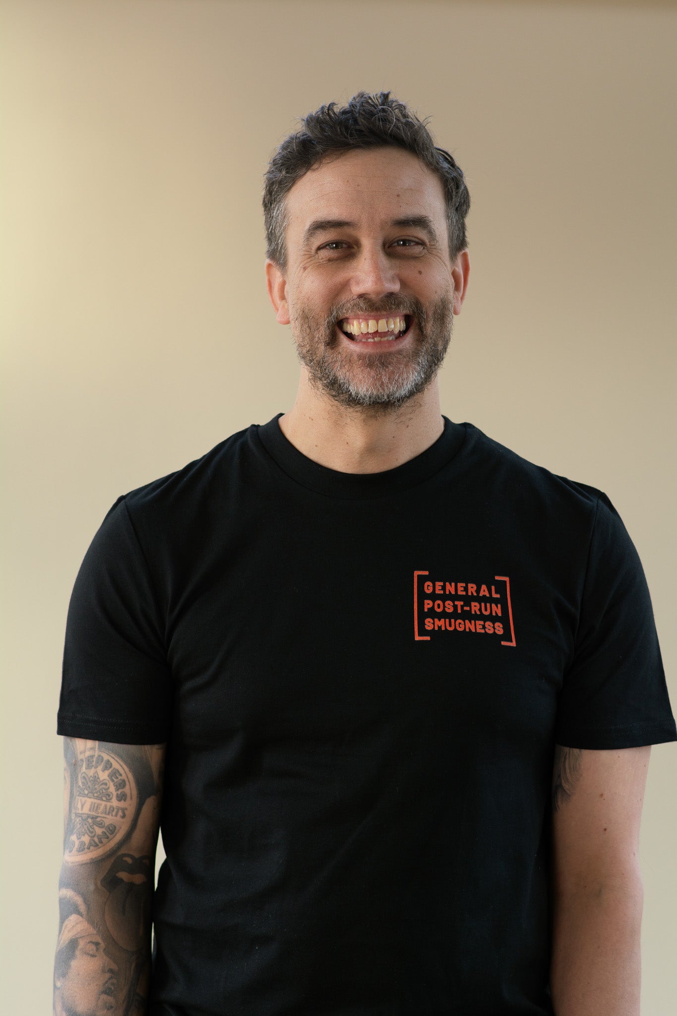 Man wearing a black t-shirt with orange text on a beige background