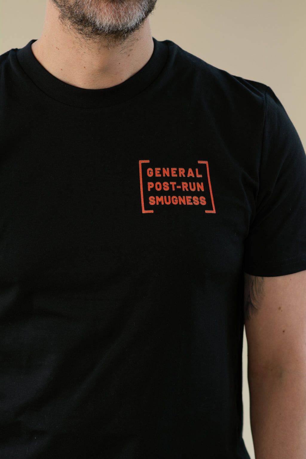 Black t-shirt with orange text on a beige background