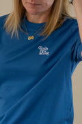 Person wearing a blue t-shirt with 'Rain or Shine' text