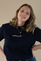 Person wearing a navy t-shirt with text on a beige background
