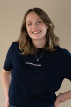 Woman wearing a navy t-shirt with text on a beige background