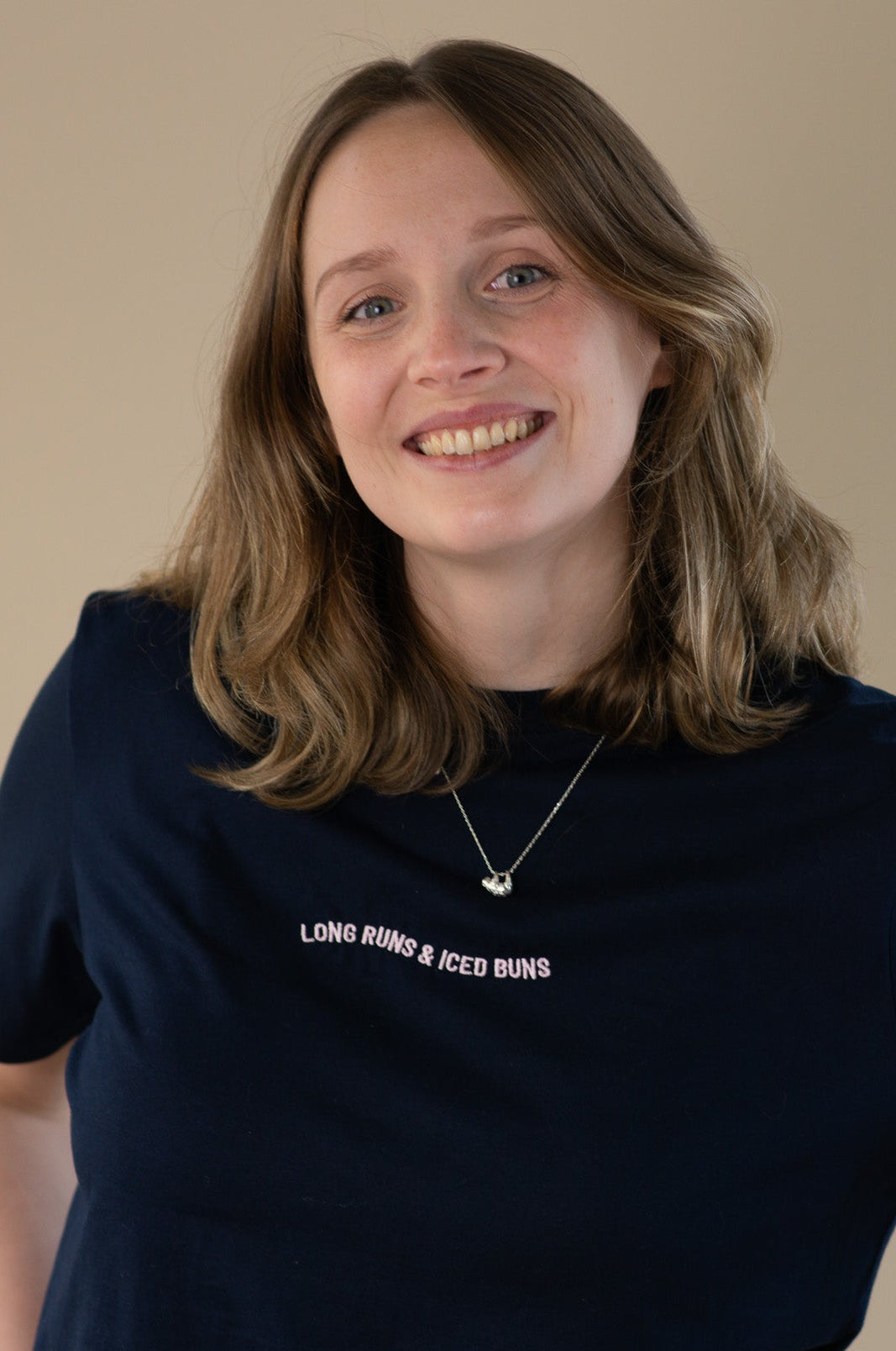 Woman wearing a black t-shirt with text on a beige background