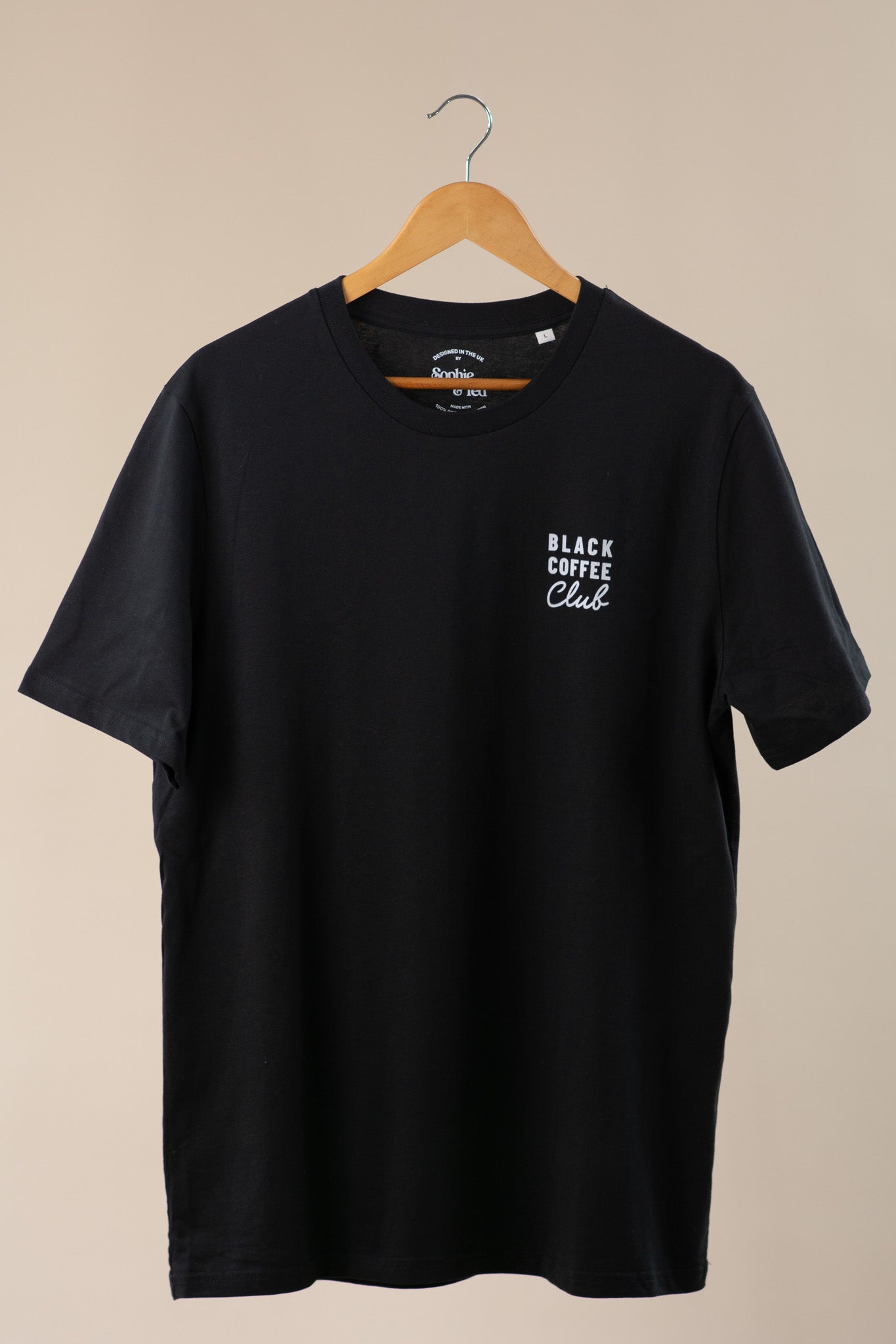 Black t-shirt with 'Black Coffee Club' text on a beige background