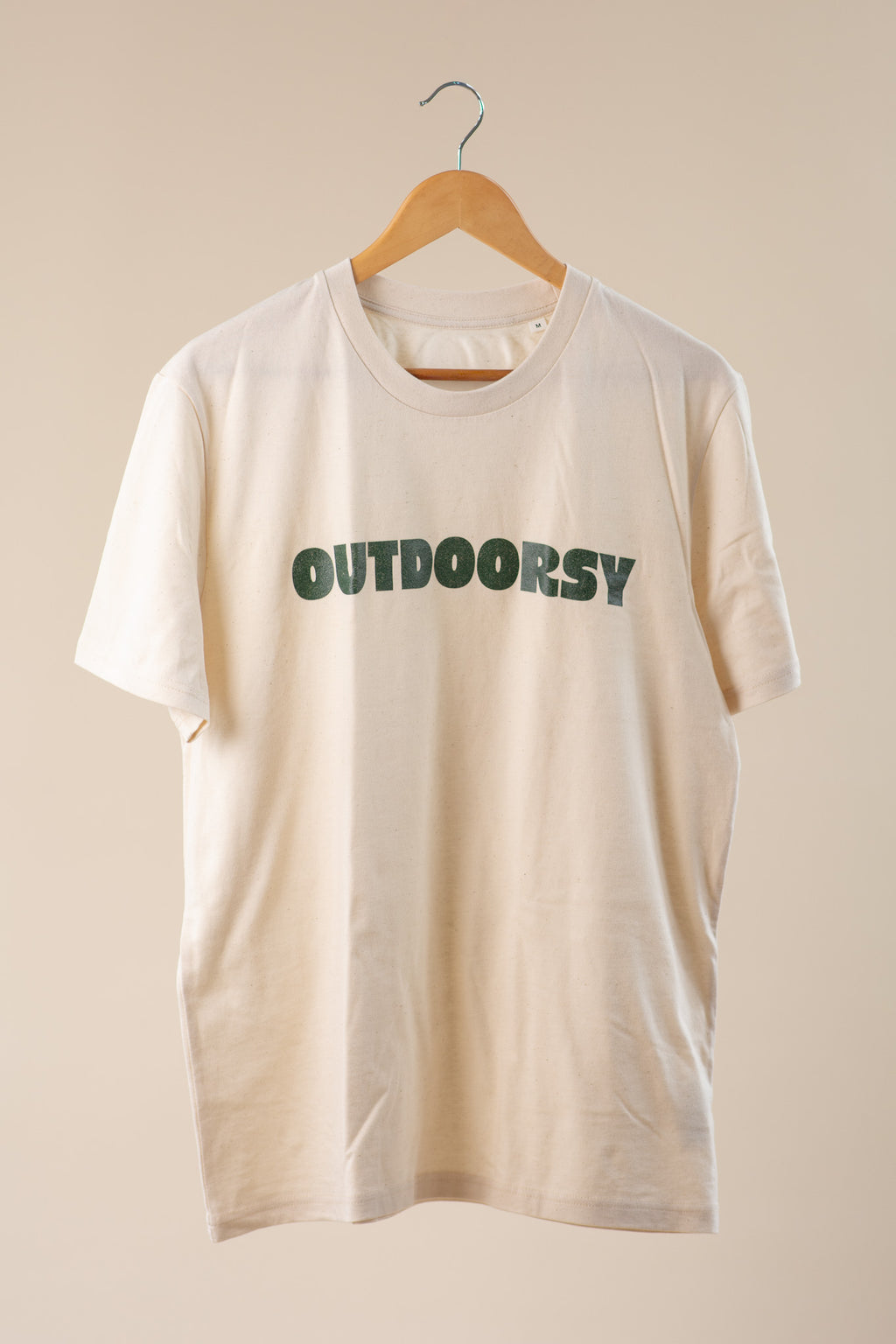 Beige t-shirt with 'OUTDOORSY' text on a beige background