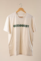Beige t-shirt with 'OUTDOORSY' text on a beige background