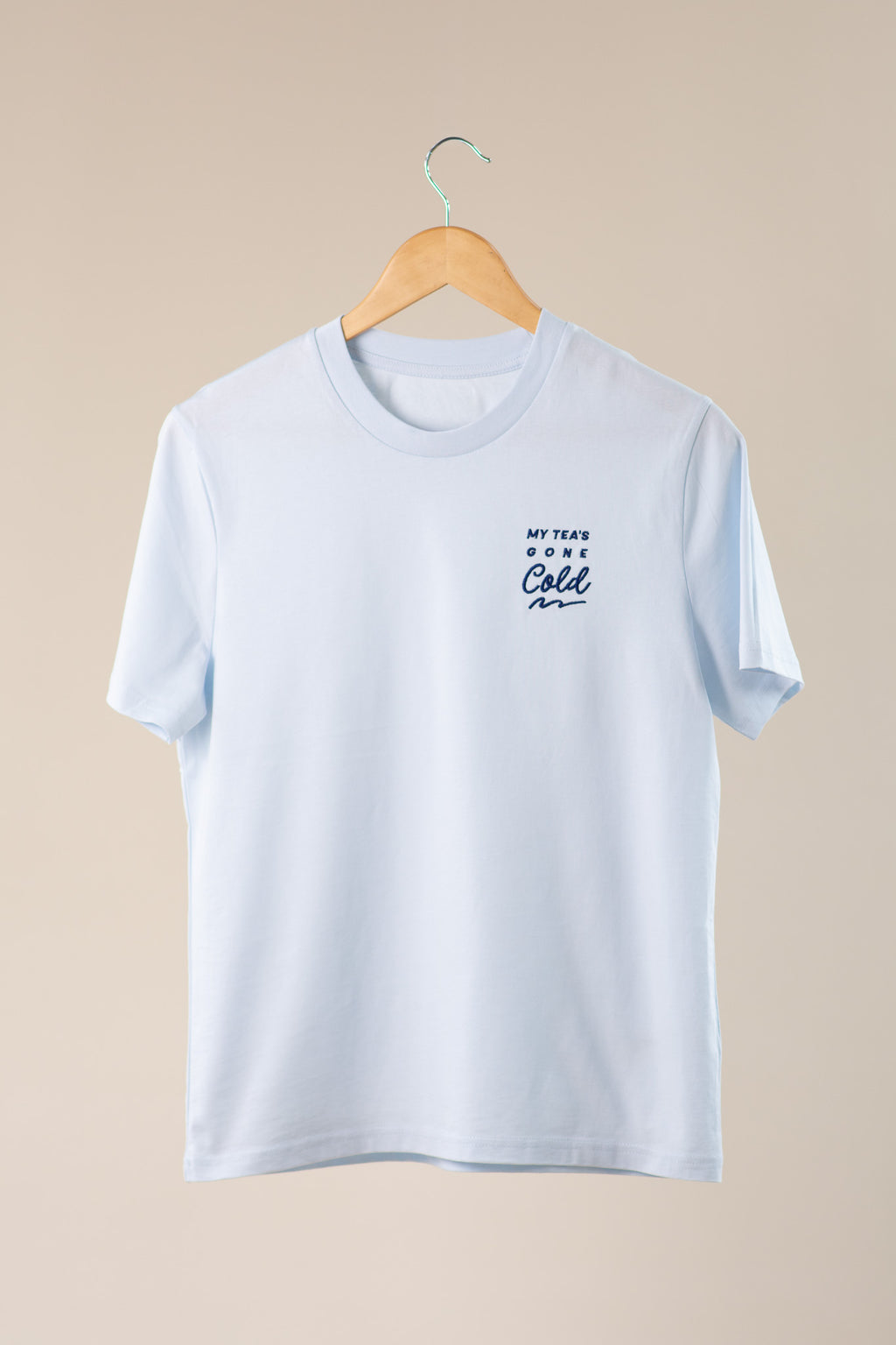Blue t-shirt with 'My Tea's Gone Cold' text on a beige background