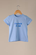 Light blue t-shirt with 'FUNNY FISH' text on a wooden hanger against a beige background