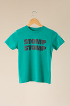 Green t-shirt with 'STOMP STOMP' text on a beige background