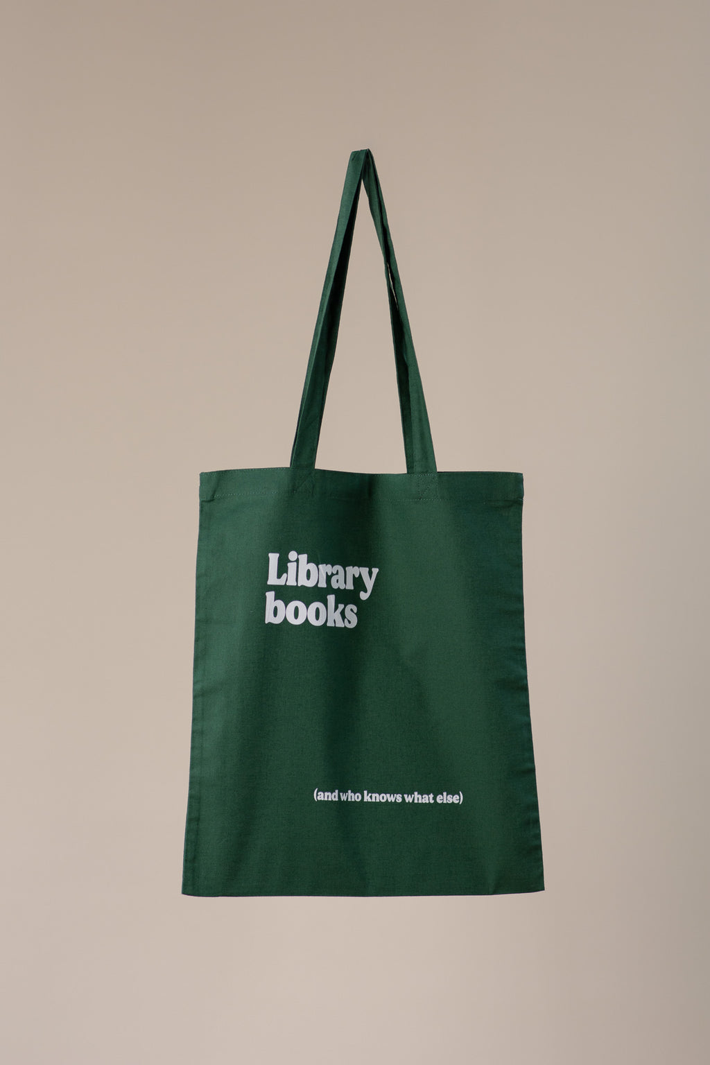 Green tote bag with 'Library books' text on a beige background