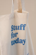 White tote bag with blue text 'Stuff for today' on a beige background