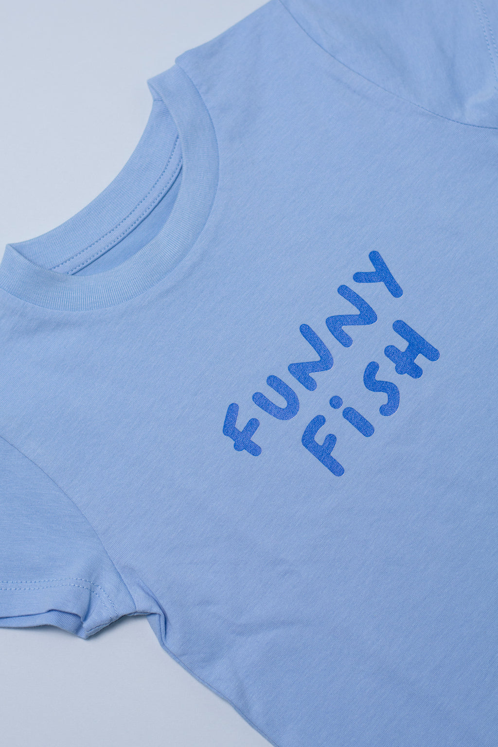 Light blue t-shirt with 'FUNNY FiSH' text on a light gray background