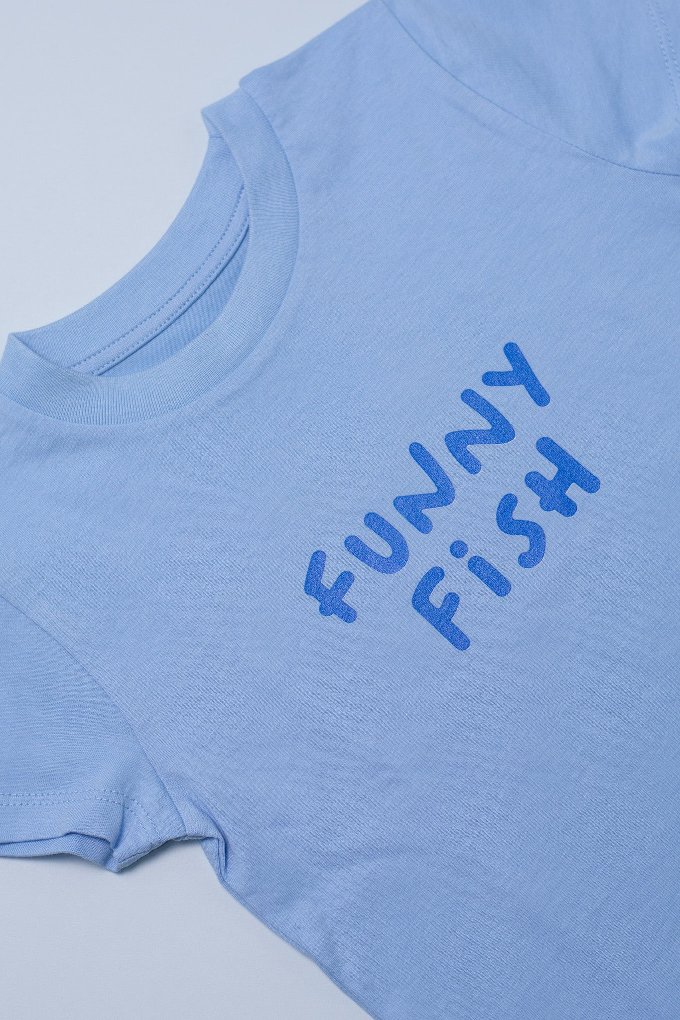 Light blue t-shirt with 'FUNNY FiSH' text on a light gray background
