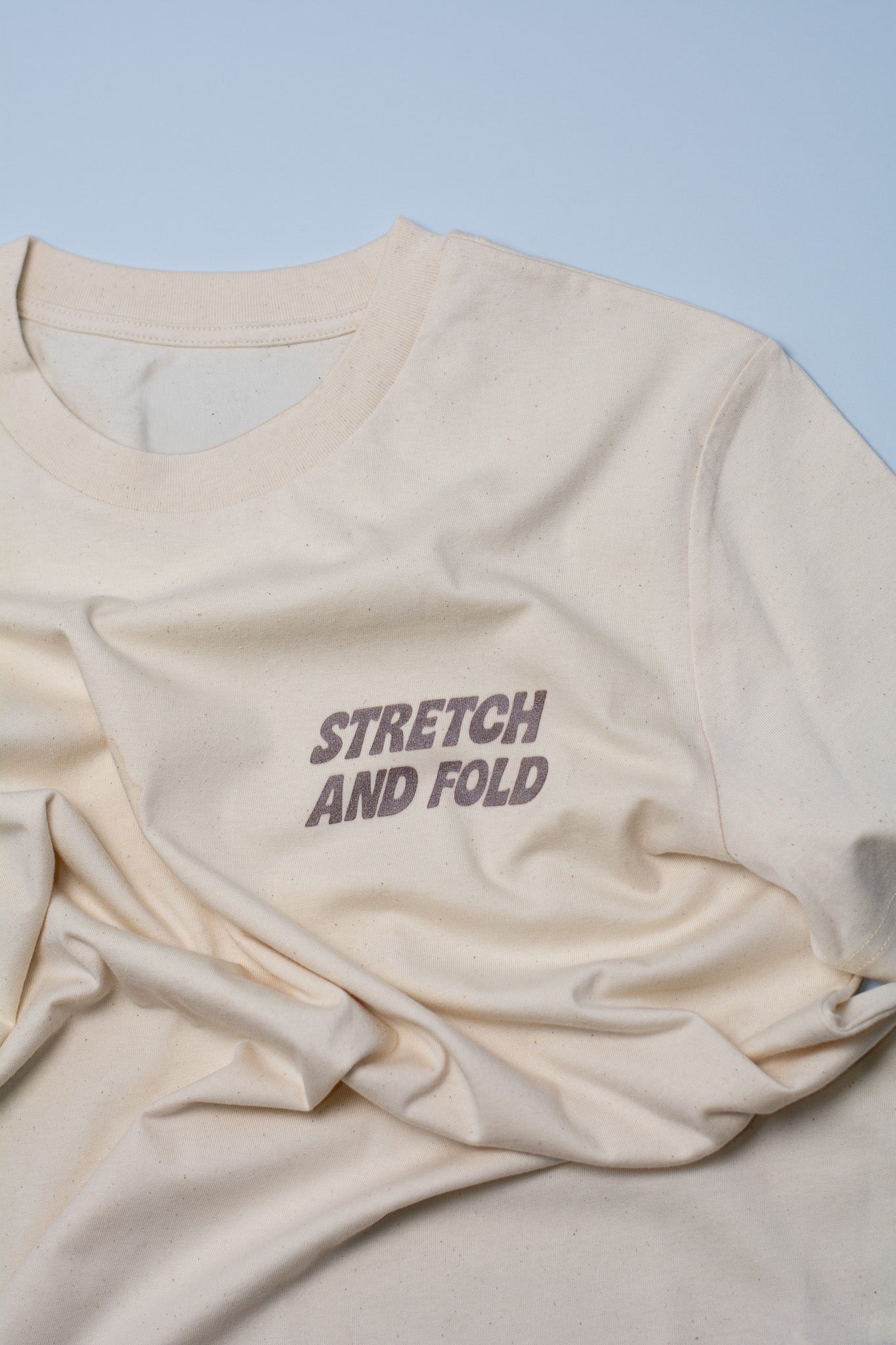 Beige fabric with 'STRETCH AND FOLD' text on a light blue background