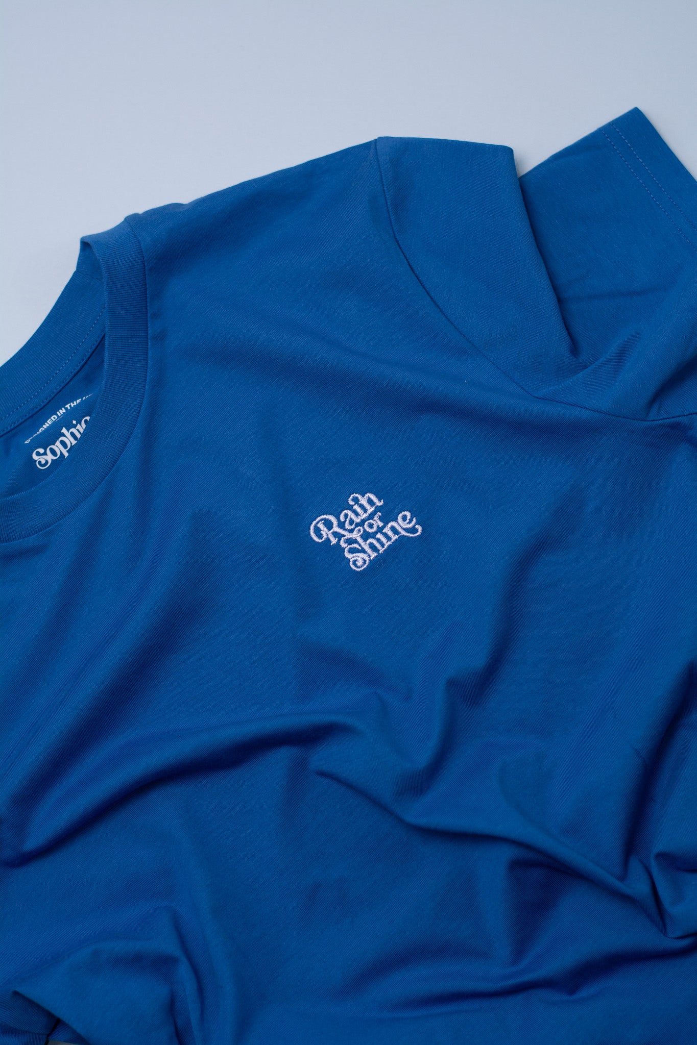 Blue t-shirt with white text on a light blue background
