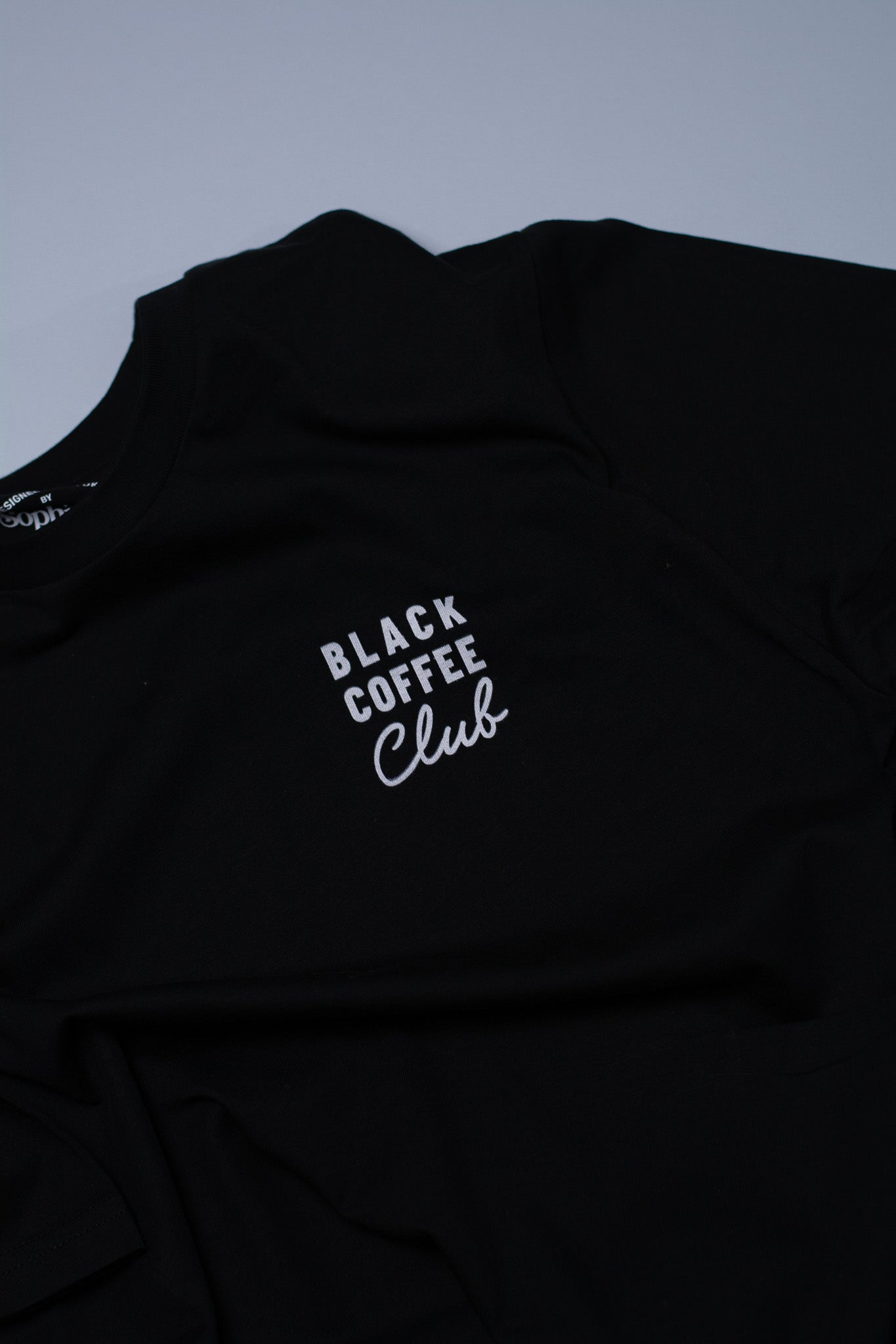 Black t-shirt with 'Black Coffee Club' text on a grey background