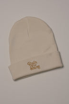 Beige beanie with 'Rain or Shine' embroidery on a light background