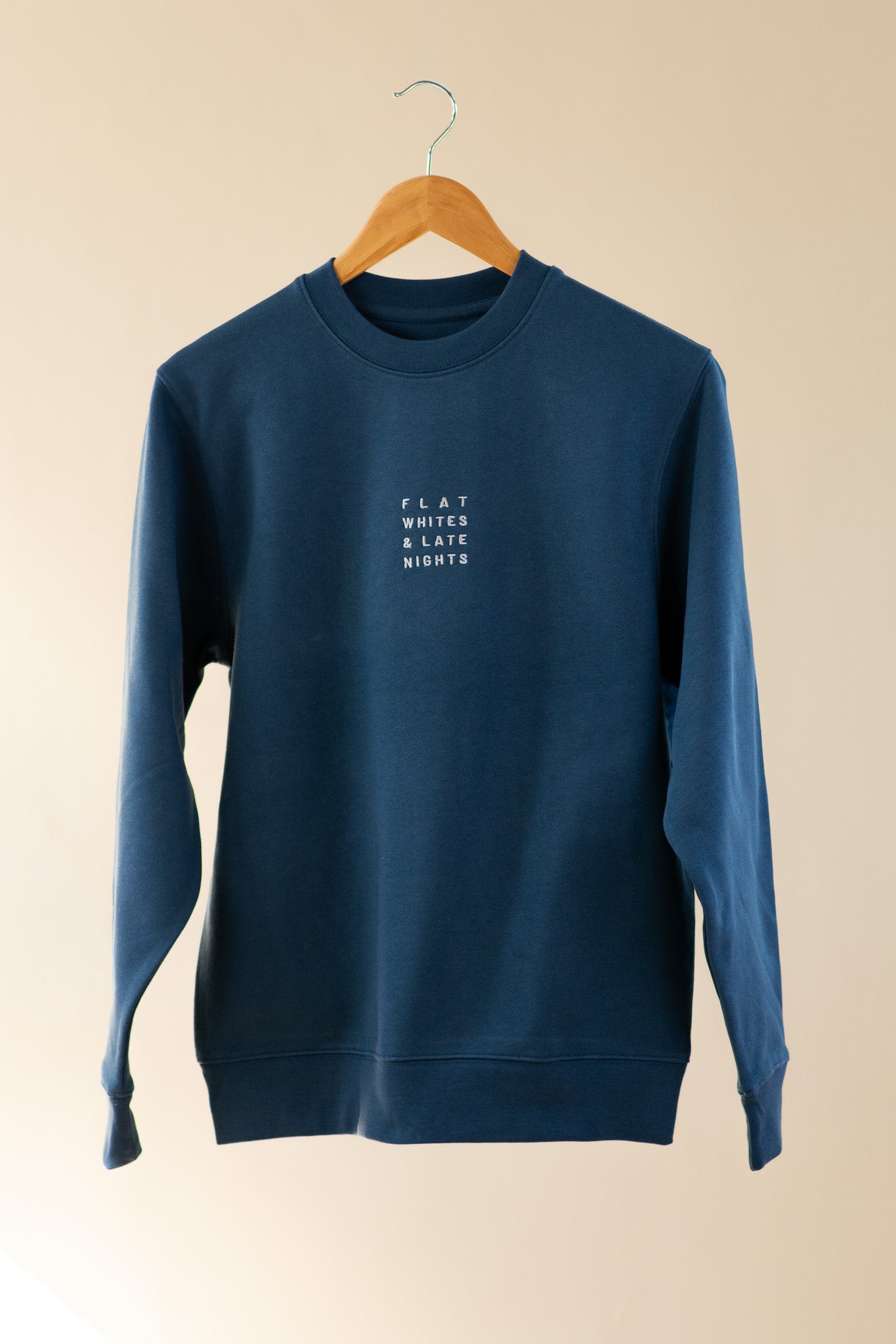 Blue sweatshirt with text on a beige background
