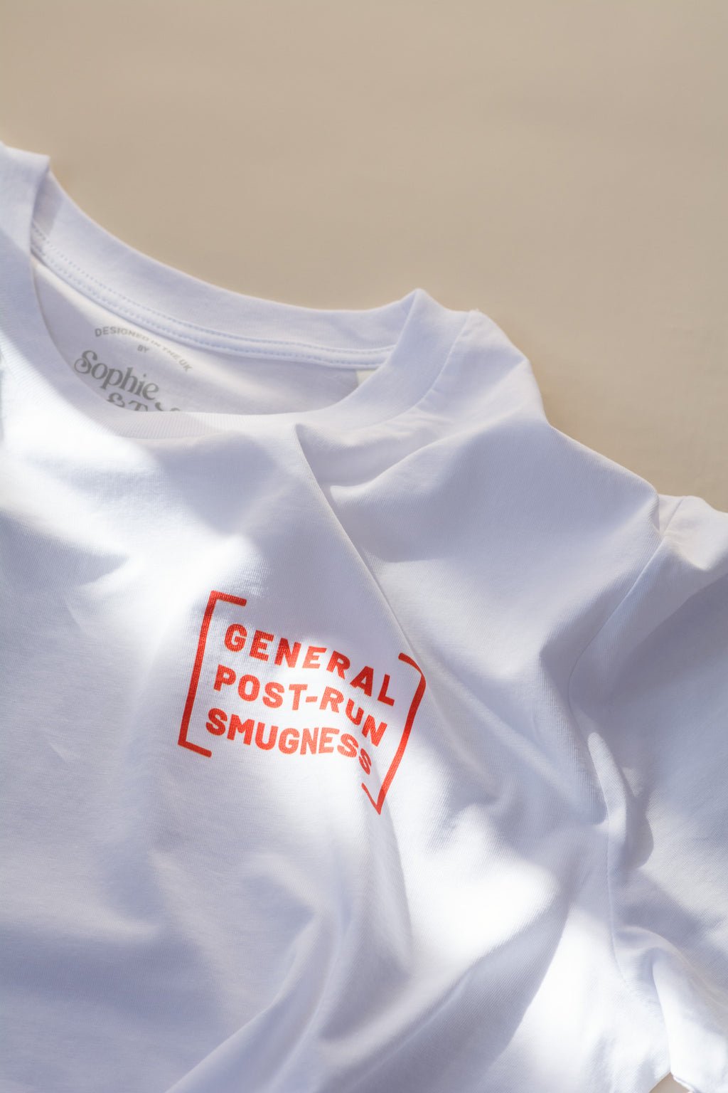 White t-shirt with red text on a beige background