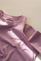 Pink t-shirt with 'overwhelmed' text on a light background