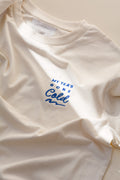 White t-shirt with blue text 'My tea's gone cold' on a light background