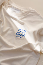 White t-shirt with blue text 'My tea's gone cold' on a light background