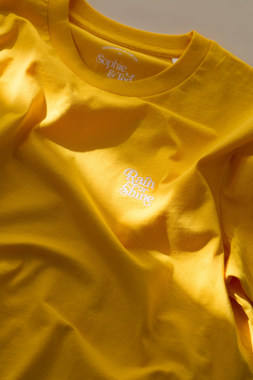 Yellow t-shirt with text on a plain background