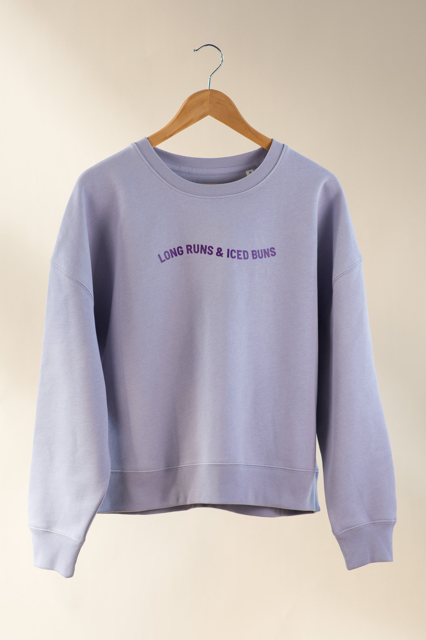 Light purple sweatshirt with text on a beige background