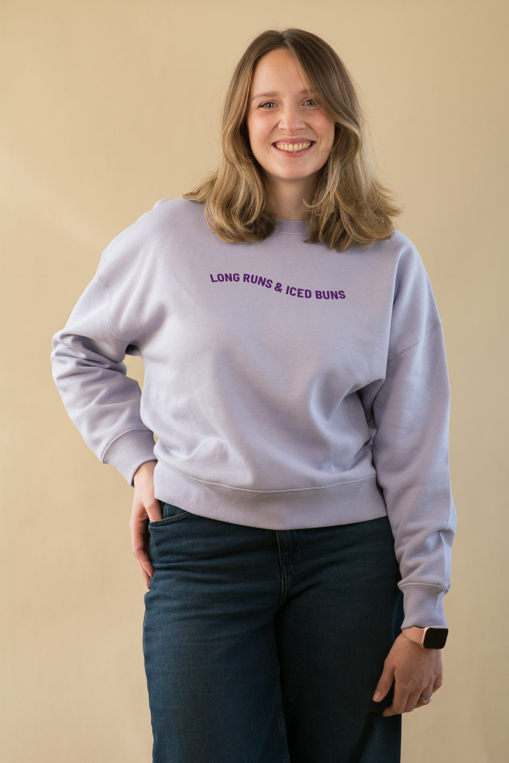 Woman wearing a light gray sweatshirt with text on a beige background