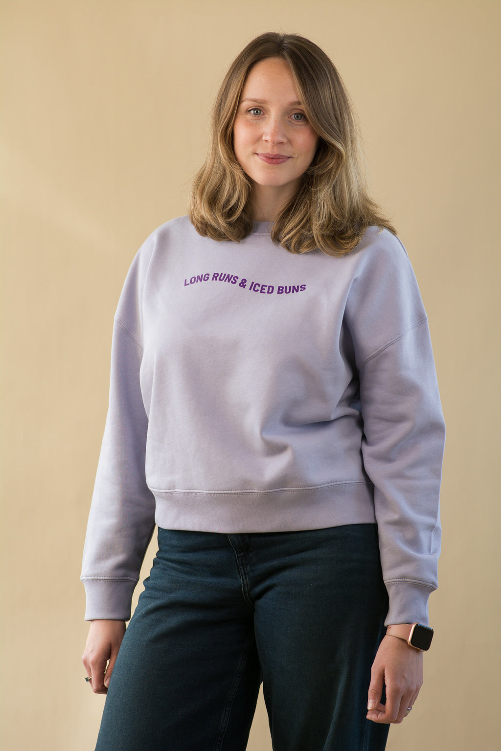 Person wearing a light gray sweatshirt with text on a beige background