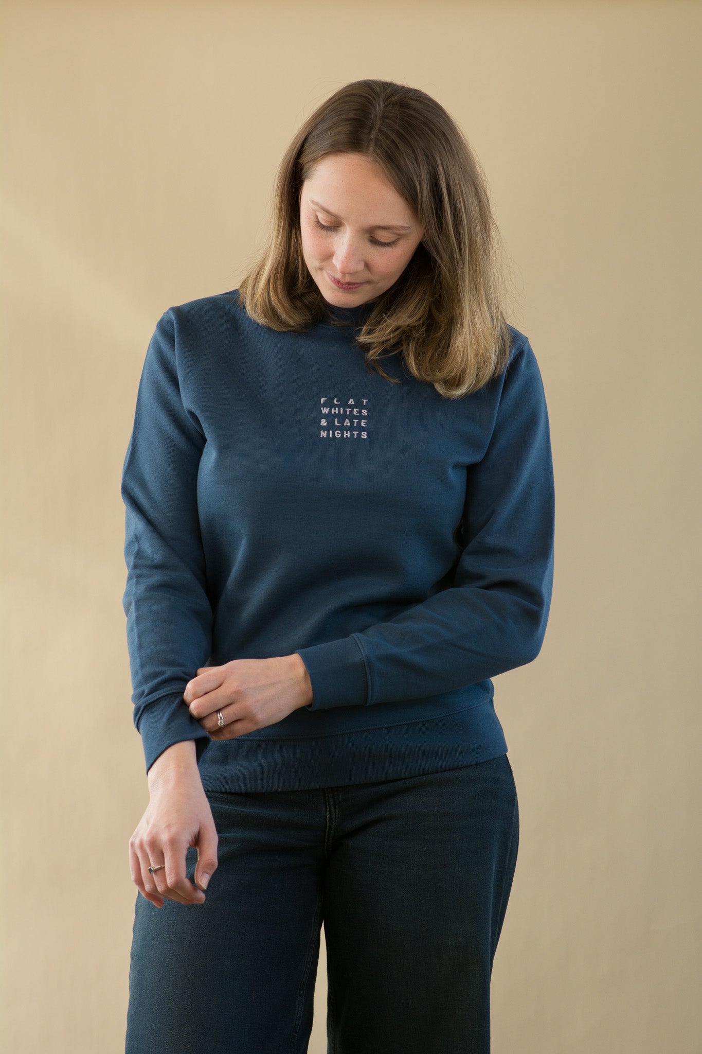 Woman wearing a blue sweater with text on a beige background