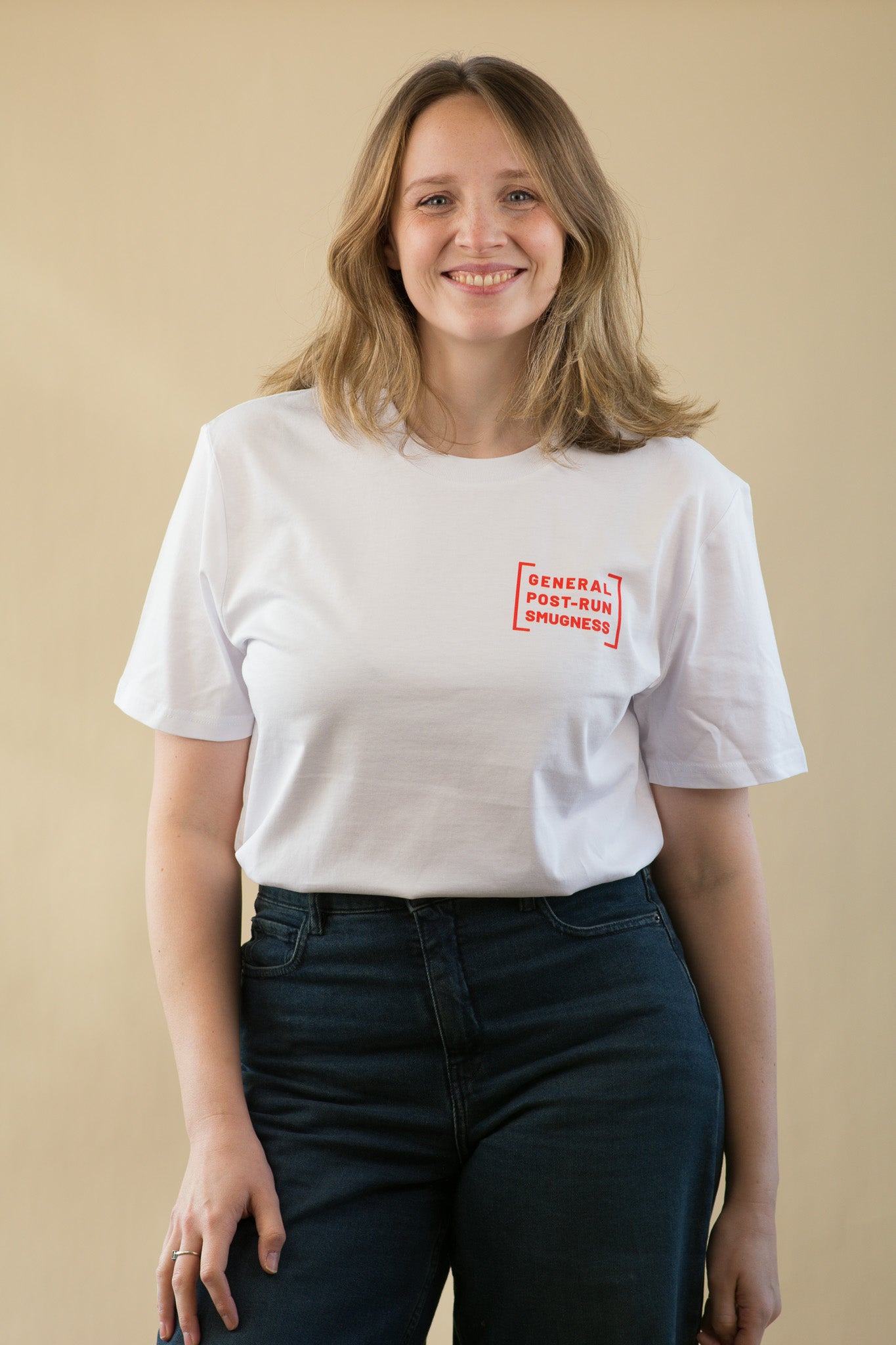 Person wearing a white t-shirt with text on a beige background