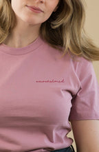 Woman wearing a pink t-shirt with text on a beige background