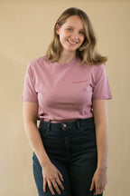 Woman wearing a pink t-shirt with text on a beige background