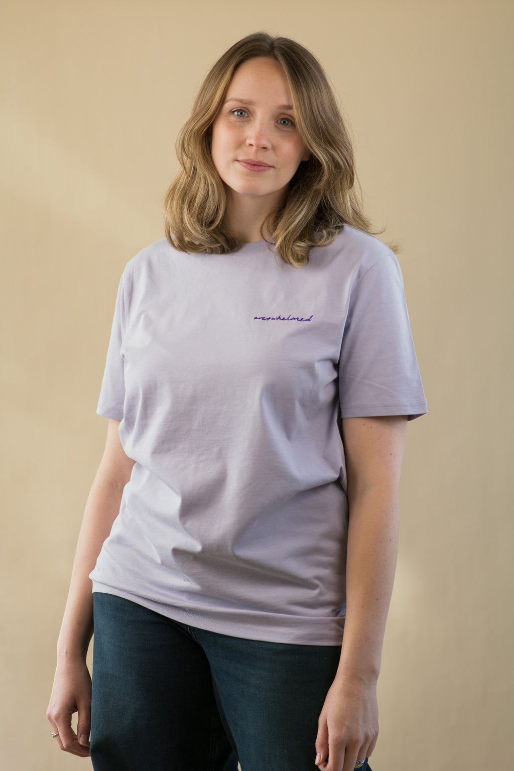 Person wearing a light gray t-shirt with text on a beige background