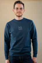 Man wearing a navy blue sweatshirt with text on a beige background
